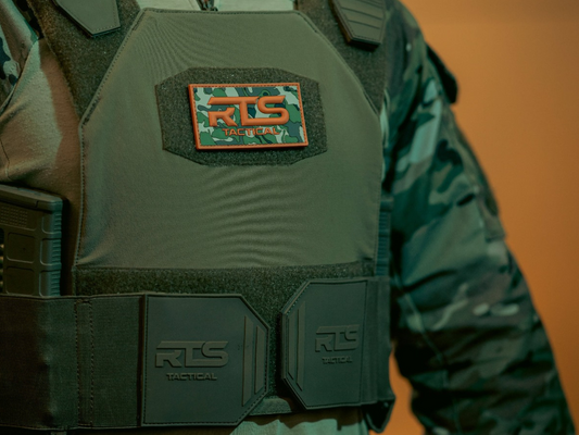 A soft body armor vest in OG Green with an RTS Multicam Velcro patch on the front.